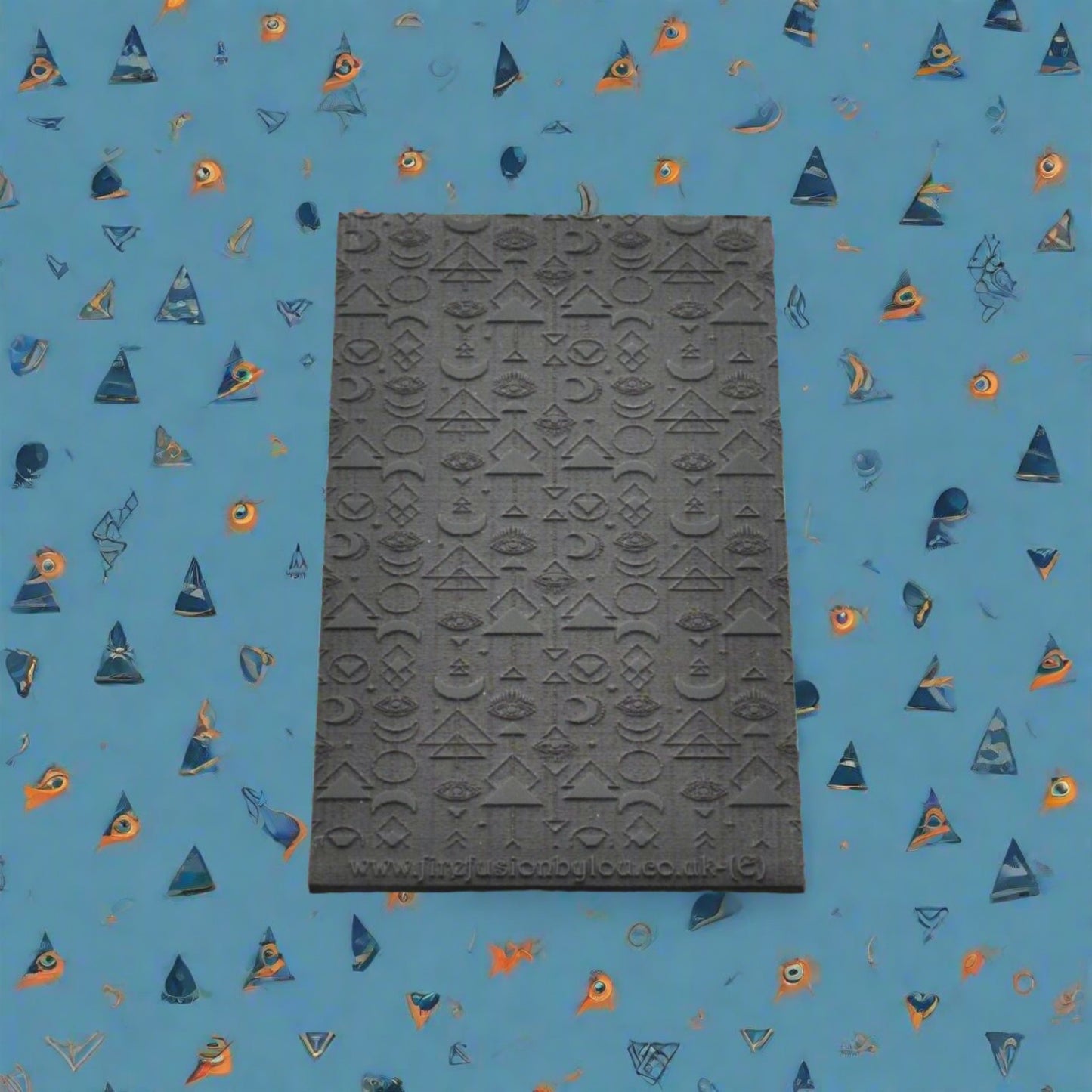 A geometric pattern repeat with mystical eyes embossed texture mat in grey material. For use on metal clay or polymer clay.