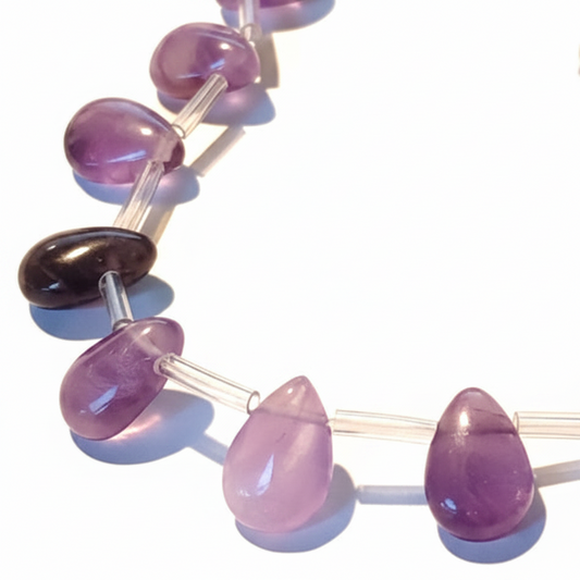 Necklace with purple teardrop beads on a light background