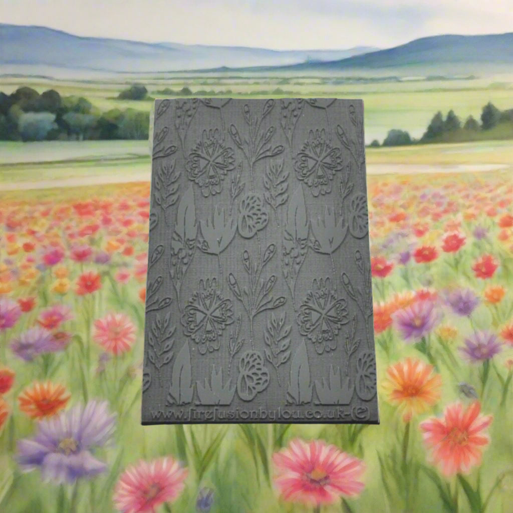 A 95 x 55 mm embossed texture mat with a flower design. Use to make a embossed impression on metal clay and polymer clay.