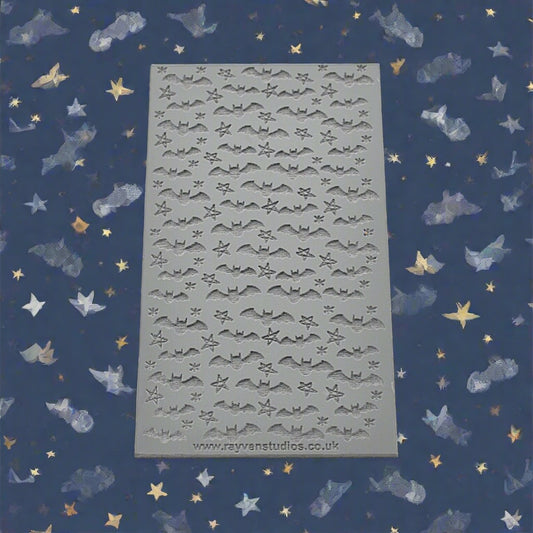 A texture mat of bats and stars debossed. Will have an embossed design on metal clay or polymer.