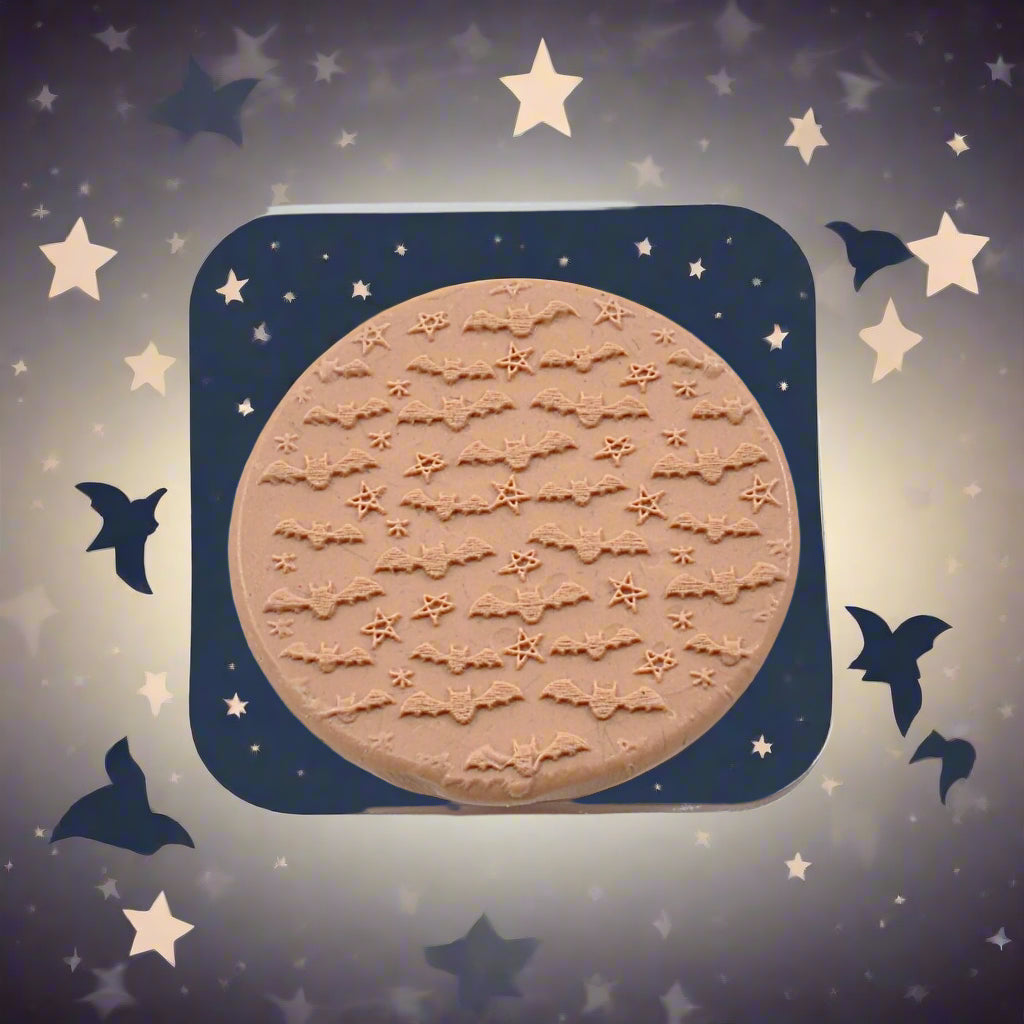 A bats and stars pattern embossed in silly putty Using a debossed texture mat. This will give you an idea of what it will look like on metal clay or polymer clay.
