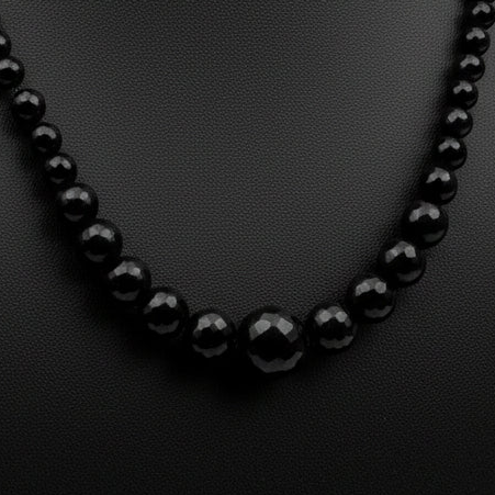 Black beaded necklace on a dark textured background