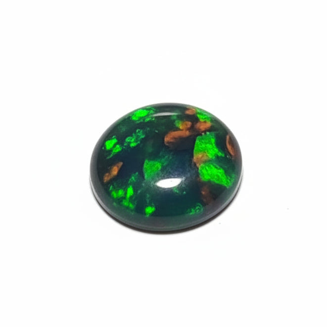 A single round cabochon gemstone with a dark green to black base and vivid flashes of green, orange, and blue iridescence, photographed on a plain light background.