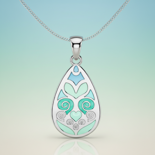 Teardrop-shaped pendant with decorative design on a gray background