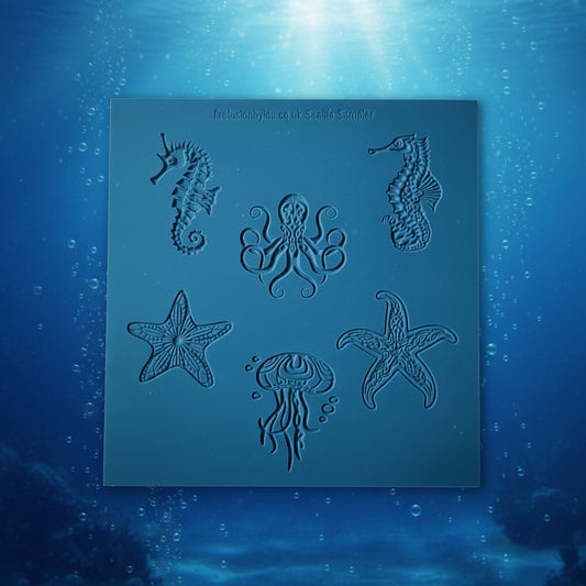 A square blue debossed rubber stamp featuring sea life designs including seahorses, starfish, a jellyfish, and an octopus, displayed on an underwater background.