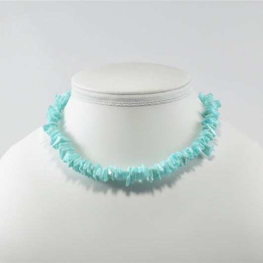 Turquoise necklace on a mannequin bust against a white background