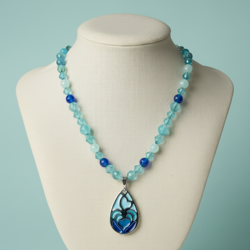 Necklace with blue and green beads on a mannequin against a light blue background