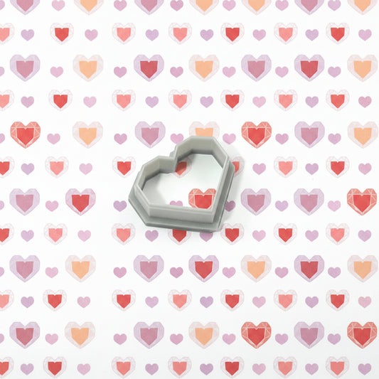 Heart-shaped cutter on a background of pink and red heart patterns