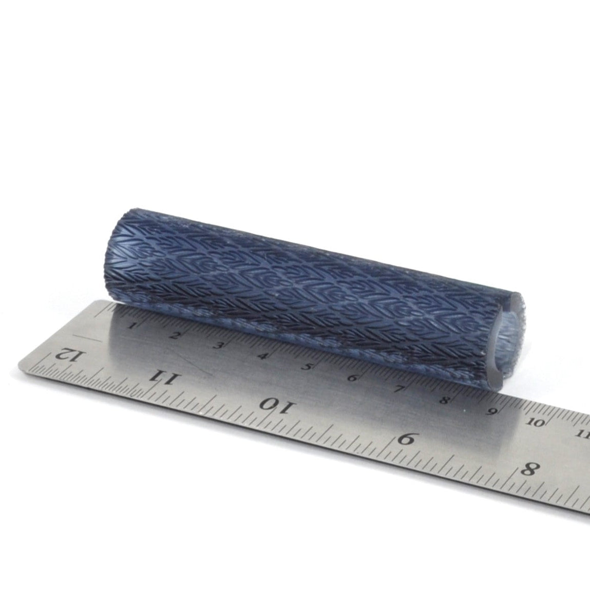 Roll of blue patterned leaves on a metal ruler for measurement