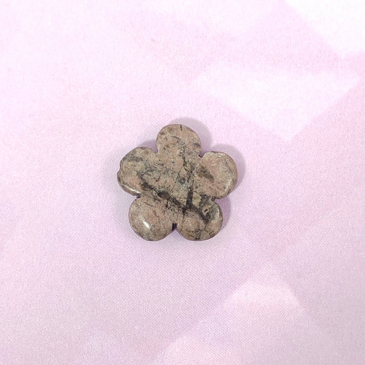 Flower-shaped stone on a light pink background