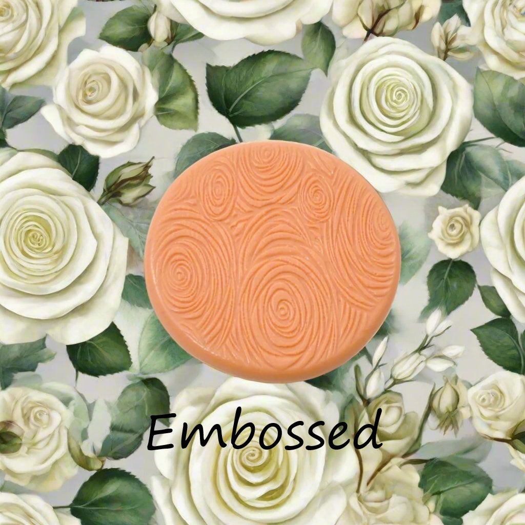 A rose pattern debossed in silly putty Using a small sunflower patterned debossed texture mat in grey material. This will give you an idea of what it will look like on metal clay or polymer clay.