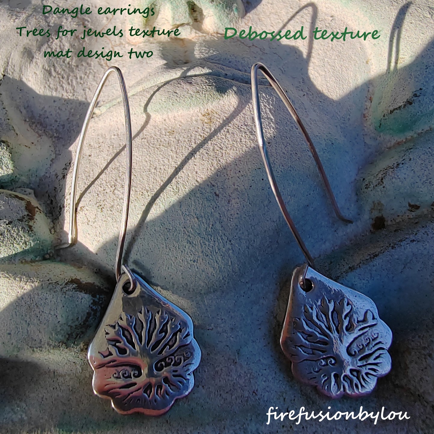 silver 999 dangle earrings with an embossed tree design and a patina added to the earrings. The silver has been embossed using tree for jewels texture mat design two