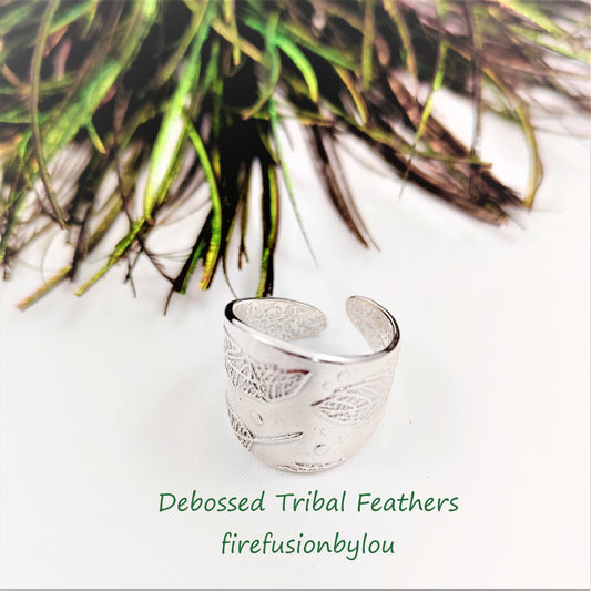 A ladies cuff ring made in 999 fine silver with an embossed tribal feathers design wrapped around the ring