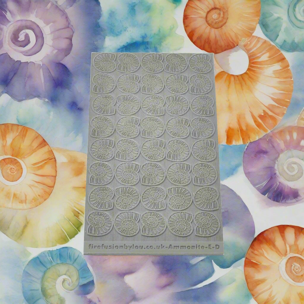 A 95 x 55 mm texture mat with embossed and debossed ammonite in a repeat pattern. Use to make a impression on metal clay and polymer clay.