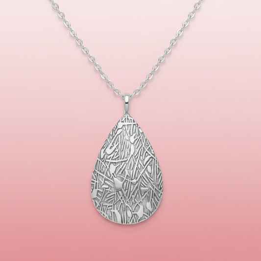 Silver teardrop-shaped pendant with intricate design on a white background
