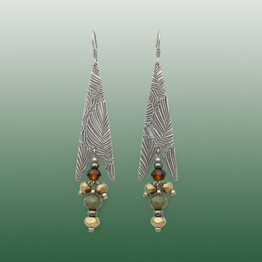 Pair of silver feather-shaped earrings with bead accents on a white background
