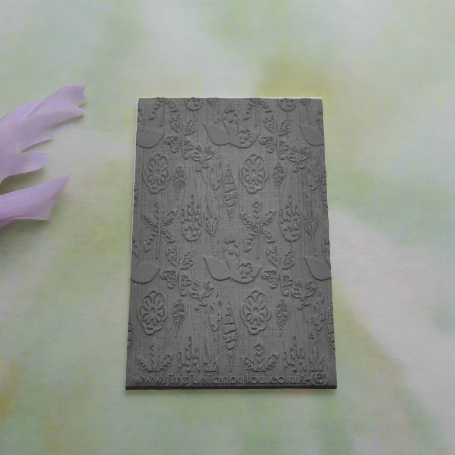 A 95 x 55 mm embossed texture mat with a flower design. Use to make a embossed impression on metal clay and polymer clay.