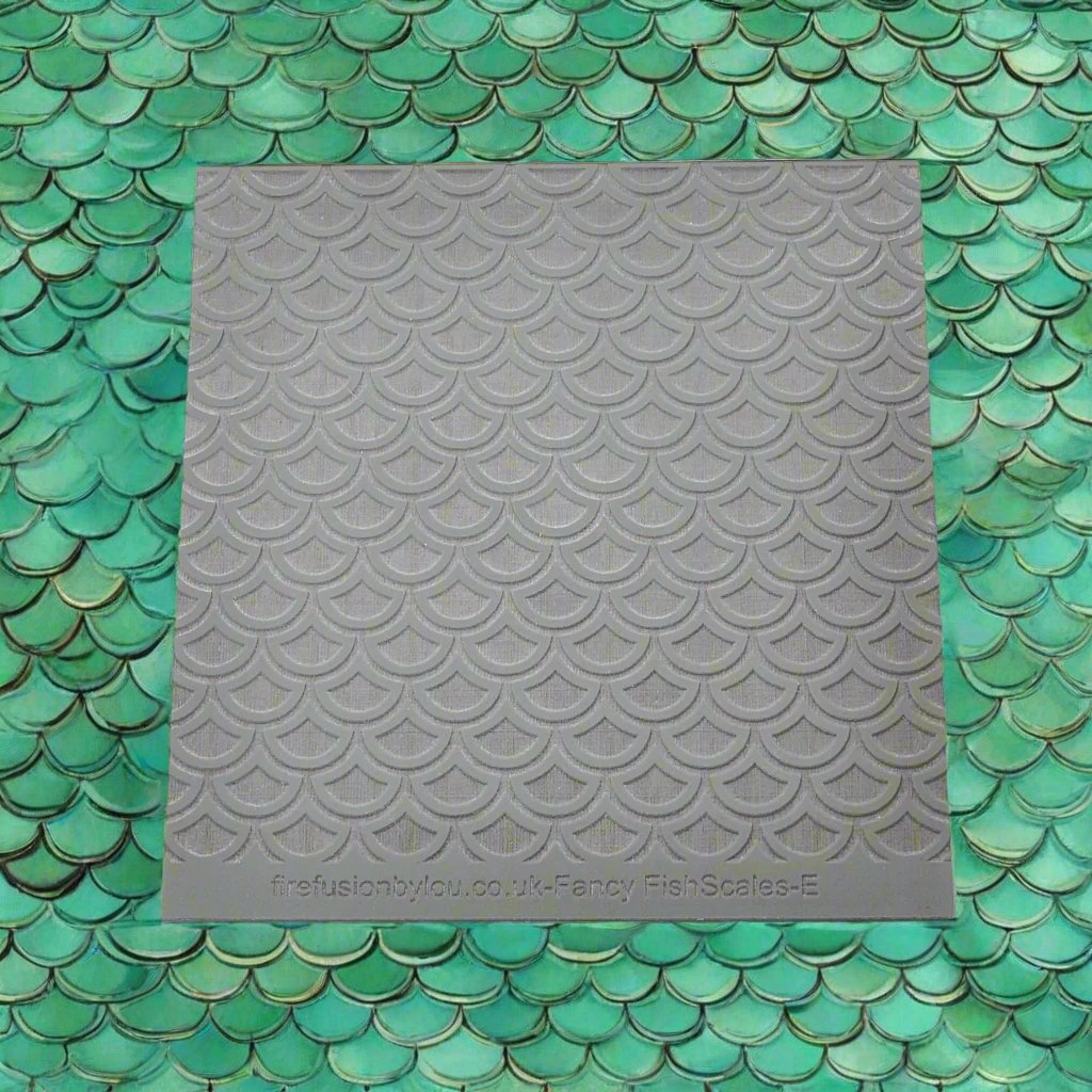 A fish scale pattern embossed texture mat in grey material. This texture mat will give you an embossed effect on metal clay or polymer clay.