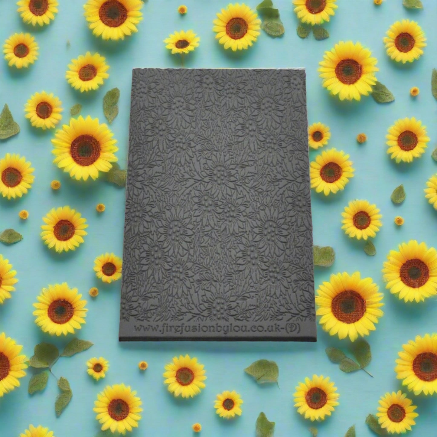 A small sunflower pattern debossed texture mat in grey material. This texture mat will give you an embossed effect on metal clay or polymer clay.