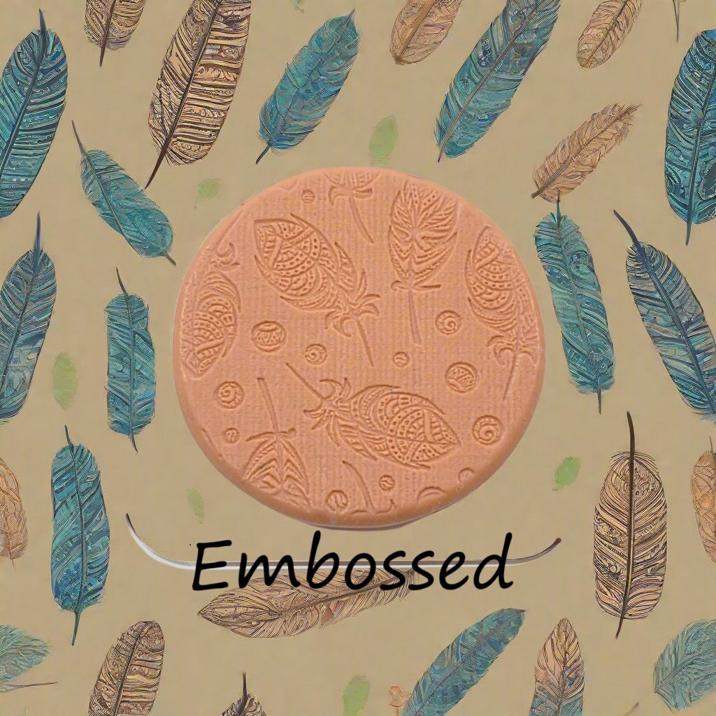A tribal feather pattern debossed in silly putty Using a patterned embossed texture mat in grey material. This will give you an idea of what it will look like on metal clay or polymer clay.