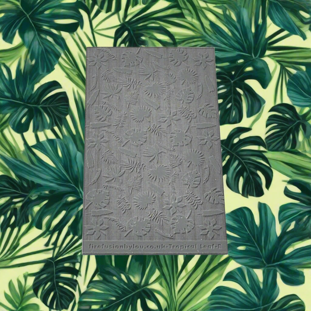 A 95 x 55 mm texture mat with small tropical leaves in a repeat pattern. Use to make a debossed impression on metal clay and polymer clay.