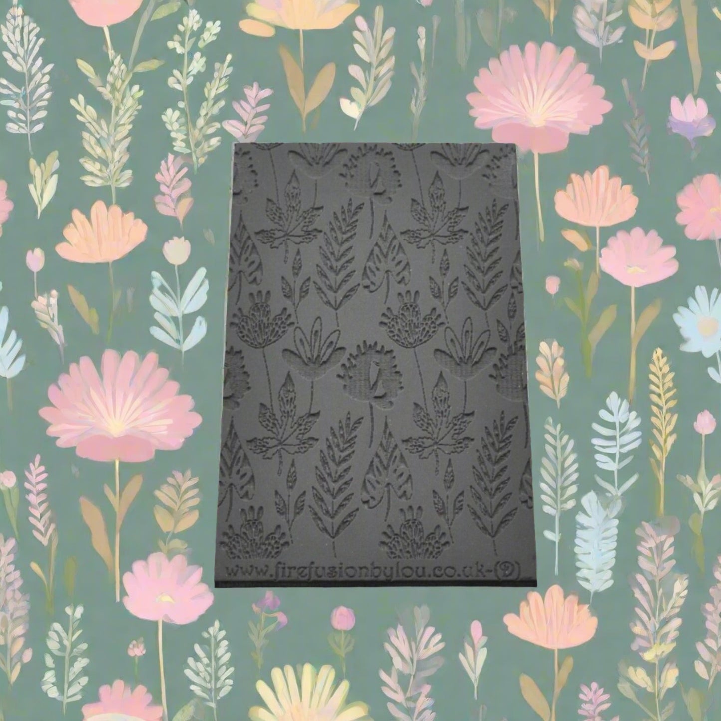 A 95 x 55 mm debossed texture mat with a flower design. Use to make a embossed impression on metal clay and polymer clay.