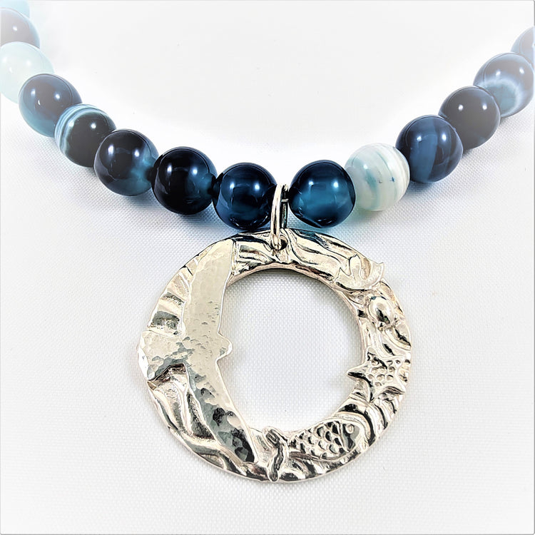 Fine silver 999 pendants with a theme of animals in nature from sea sky and land finished with semi-precious blue agate stones and 925 findings.