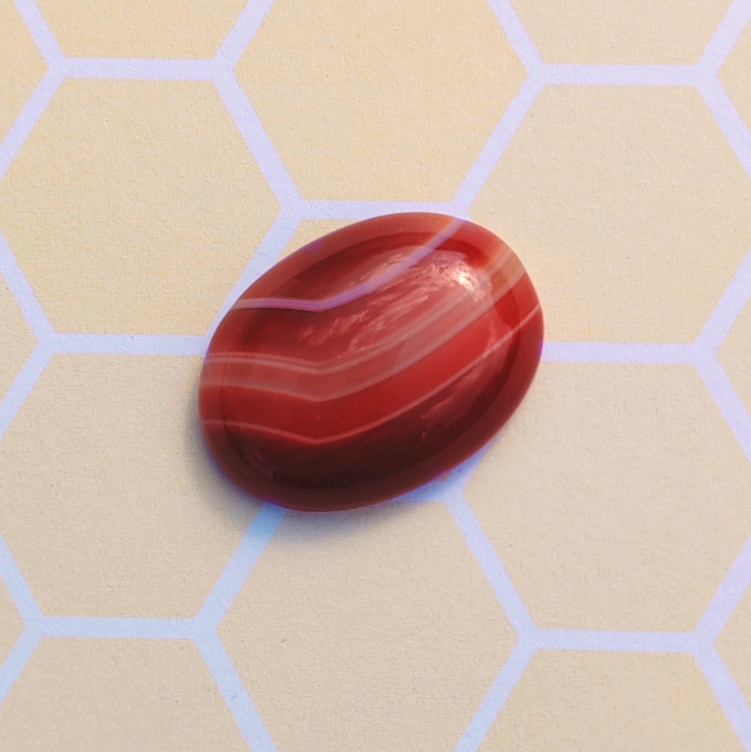 A flat backed Botswana Agate cabochon. A deep orange with the typical striped variation in colours. Size 20 x 15 millimetres