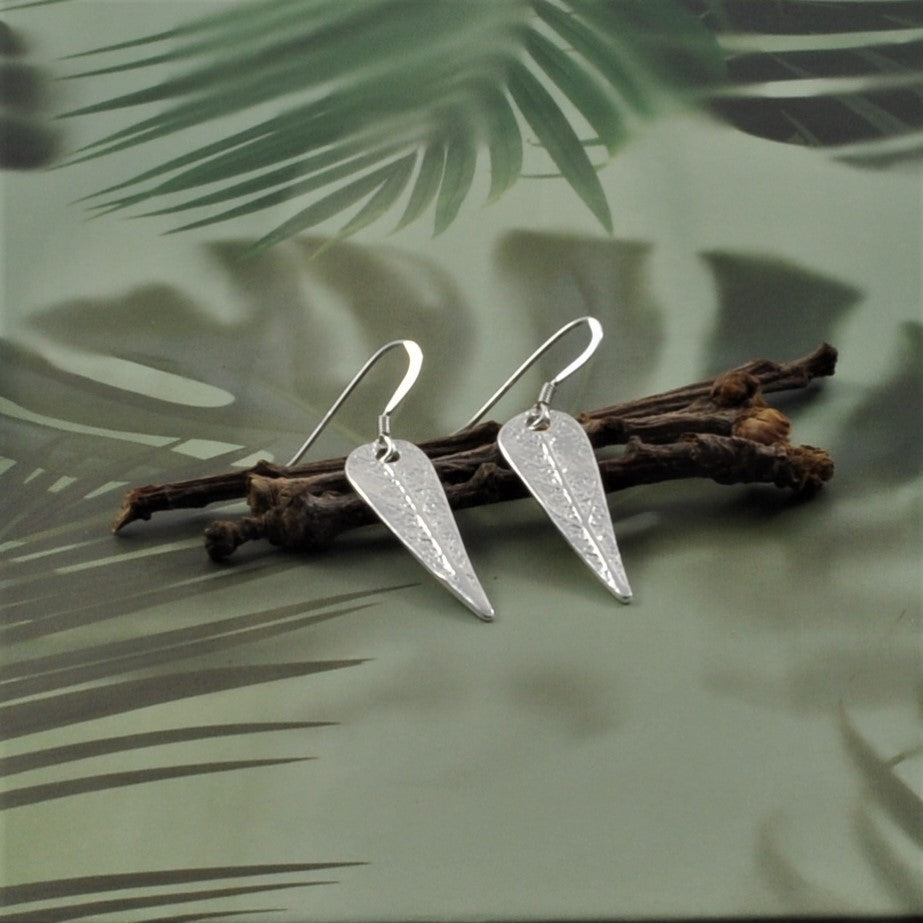 Crafted from 999 fine silver, these earrings each feature a sage leaf-shaped charm, intricately designed in various patterns and attached to 925 silver French hooks or hoops.