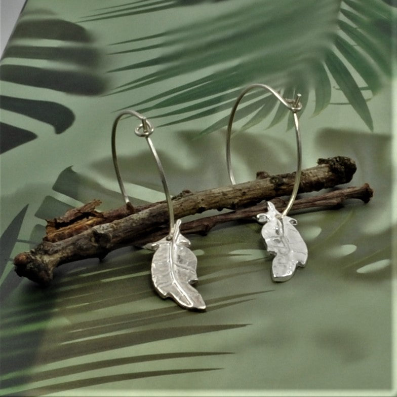 Crafted from 999 fine silver, these earrings each feature a leaf-shaped charm, intricately designed in various patterns and attached to 925 silver French hooks or hoops.