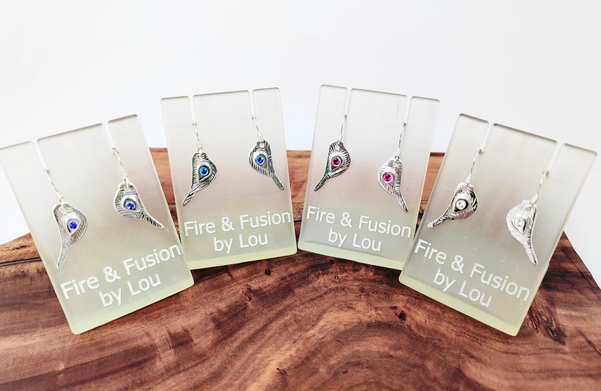 These 999 fine silver dangle earrings feature robin shapes complete with 925 sterling french hooks. Cubic zirconia stones in pink, blue, white, and purple adorn the wings.