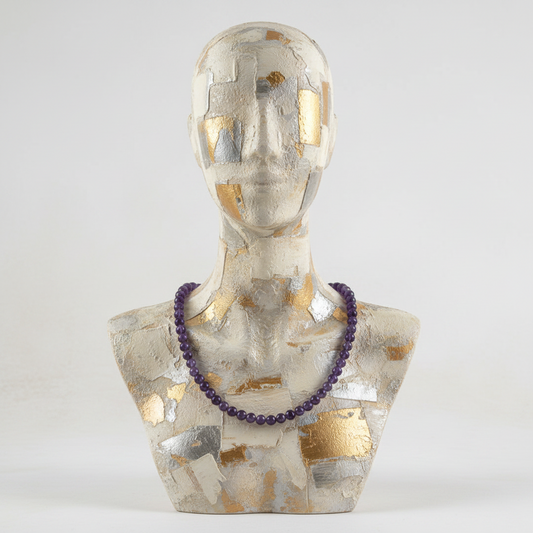 Mannequin bust with a purple necklace on a white background