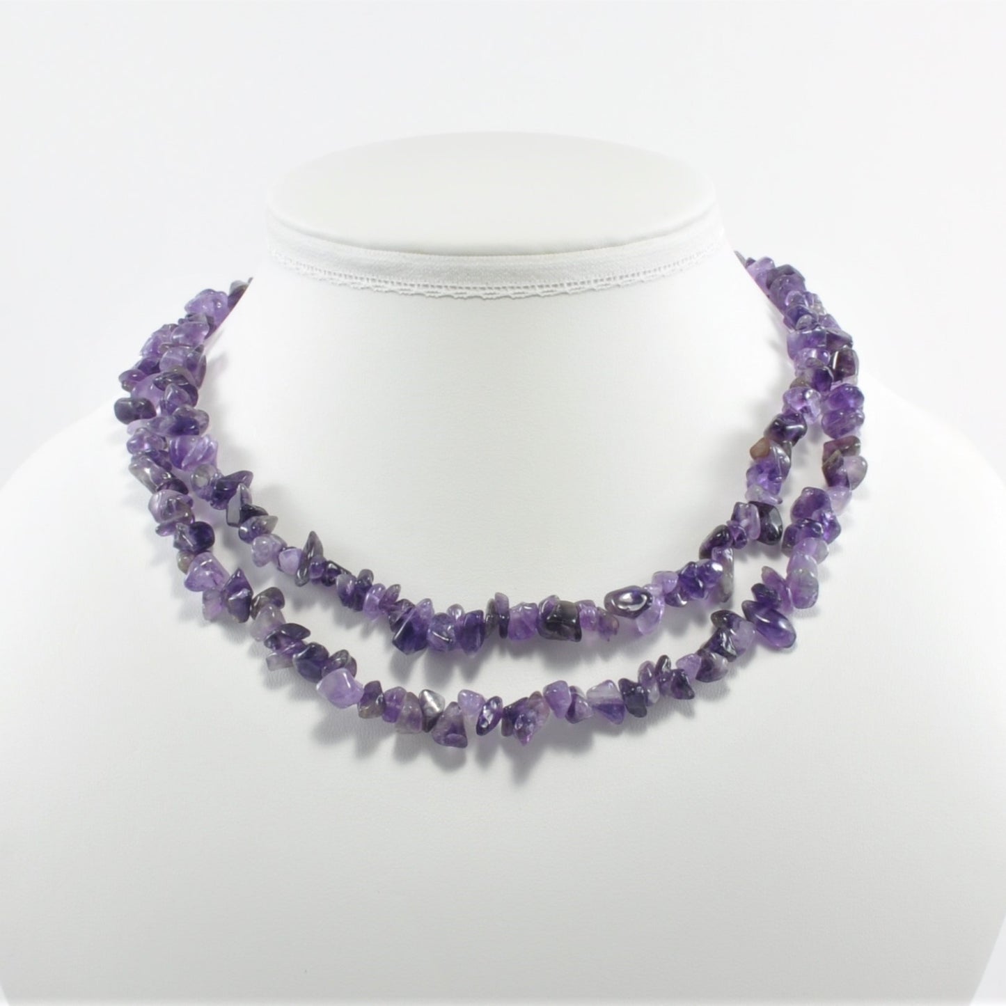 Purple beaded necklace on a mannequin with a white background