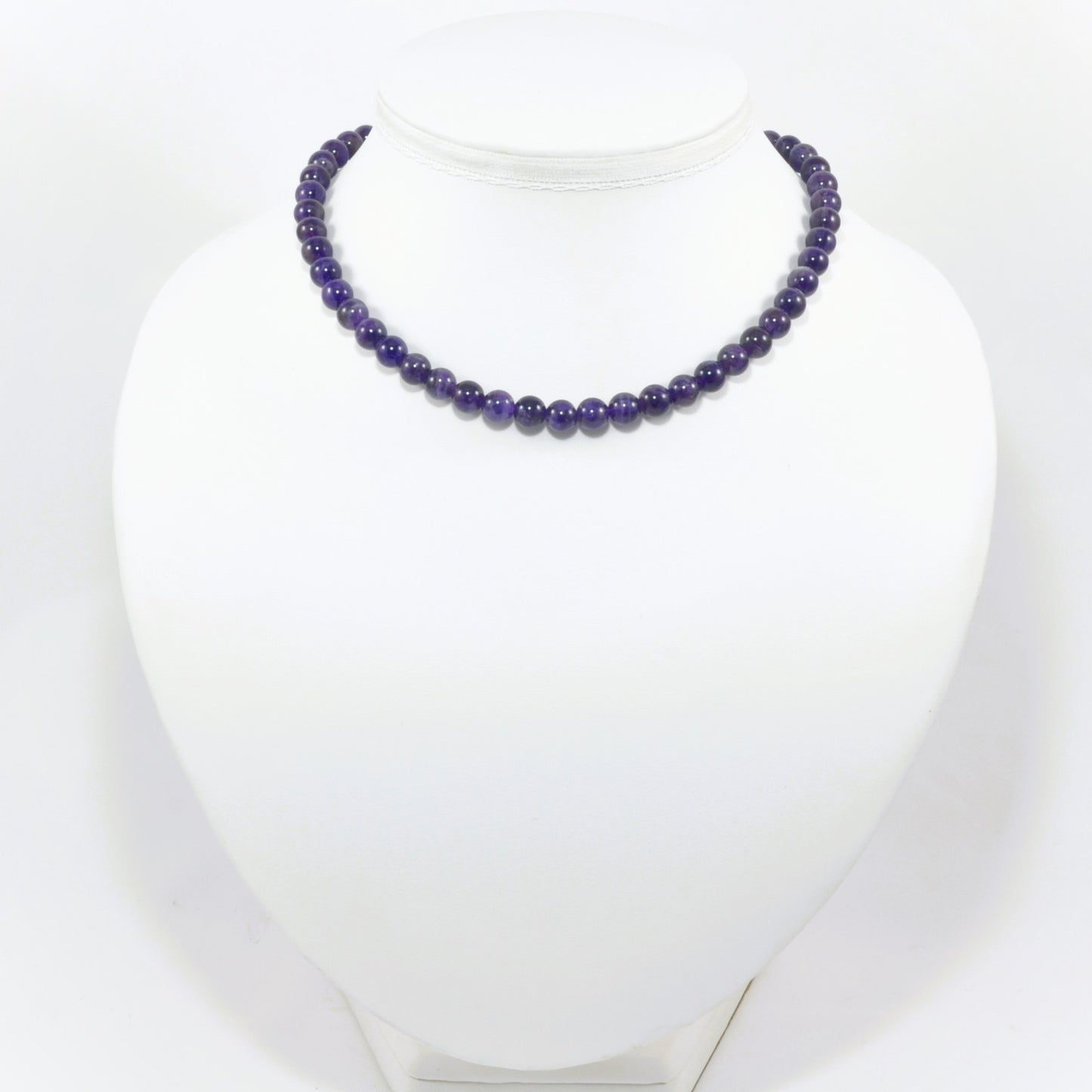 Purple beaded necklace on a white mannequin
