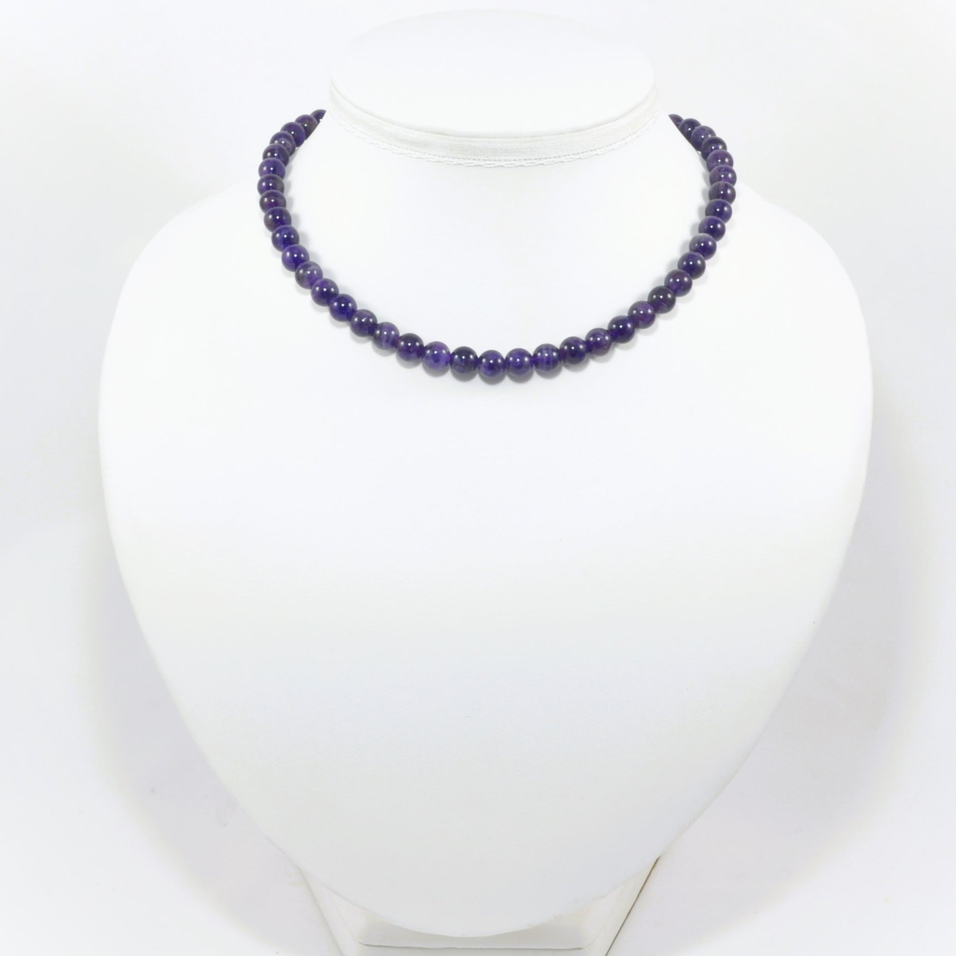 Purple beaded necklace on a white mannequin