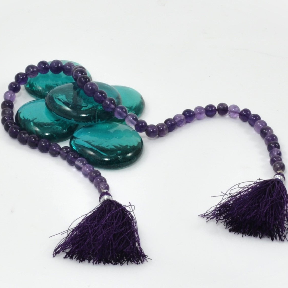 Necklace with purple beads and tassels on a white background