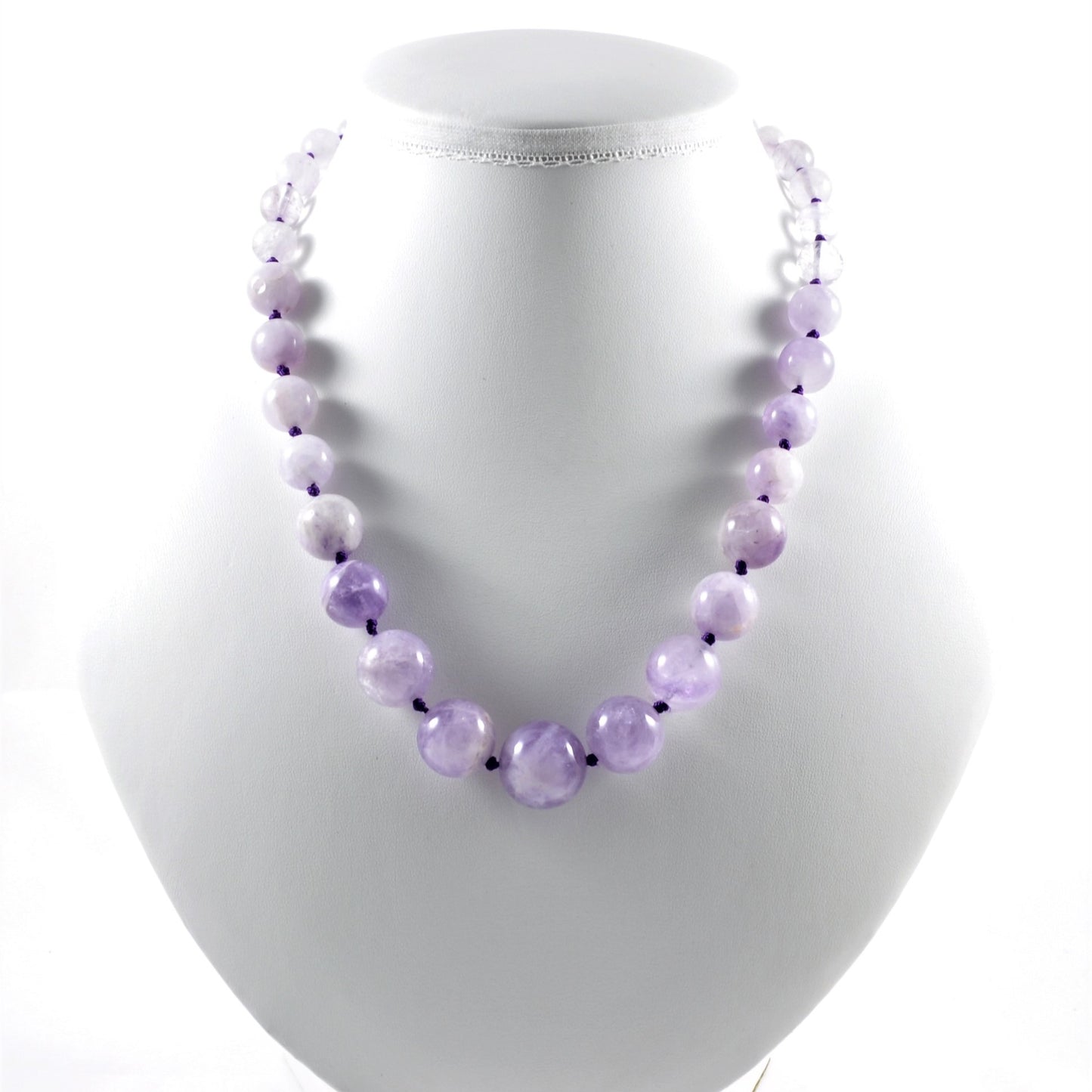 Necklace with purple beads on a white mannequin bust