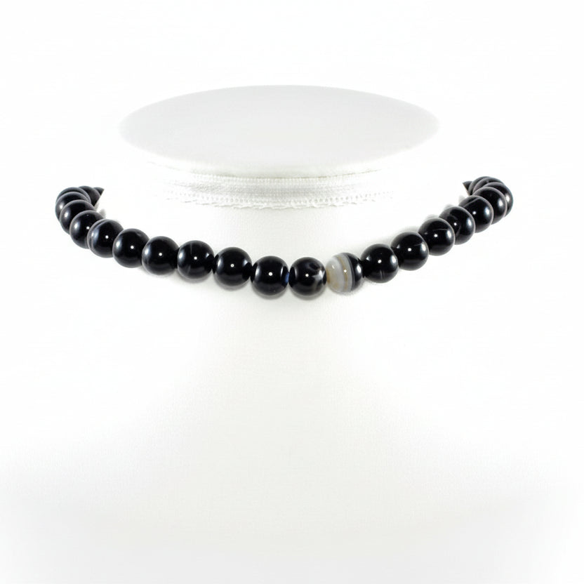 "Banded Black Agate round beads 9mm with natural white patterns on white background"
