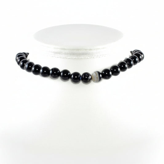 "Banded Black Agate round beads 9mm with natural white patterns on white background"