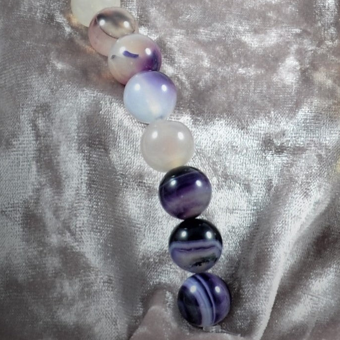 Necklace with multicolored beads on a textured silver background