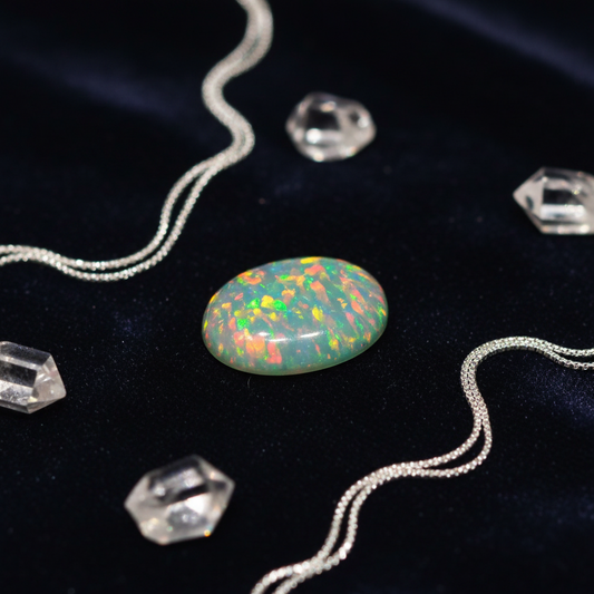Opal stone with silver chains and crystals on a dark background