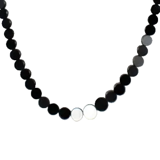 Shiny small black agate coins graduated on a strand close up view.