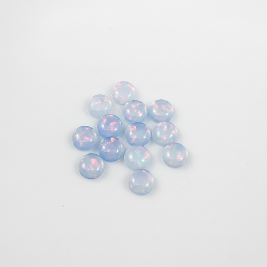 Blue with red flash Opal cabochons on a white background