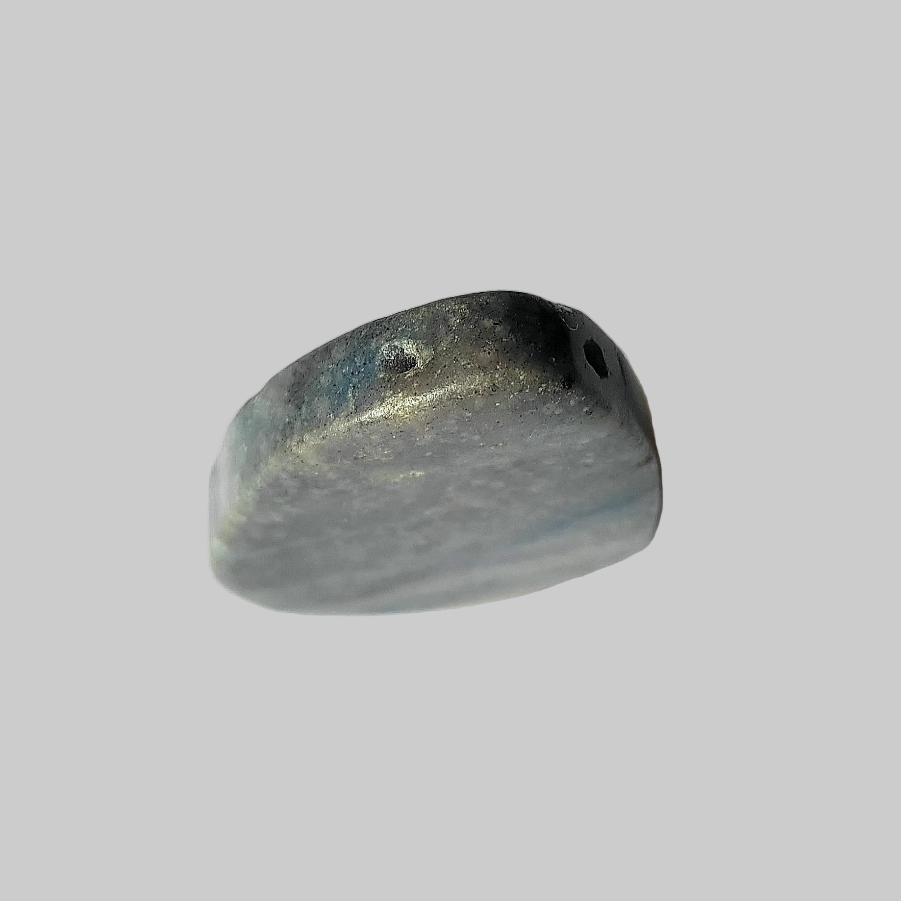 Aventurine stone with drill holes on a grey background