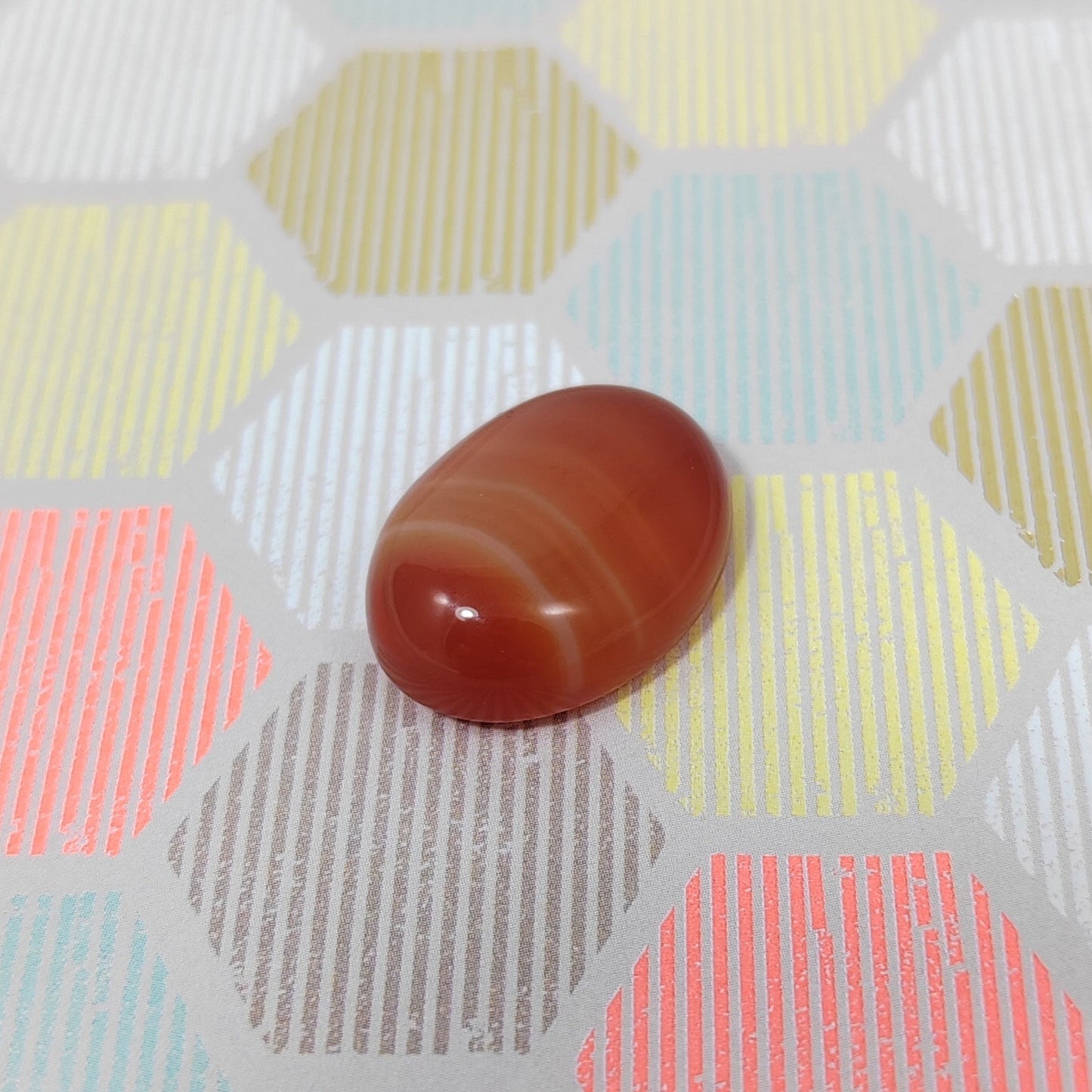 Botswana agate stone on a hexagonal patterned surface with pastel Colours