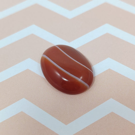 Botswana agate on a beige background with white zigzag pattern