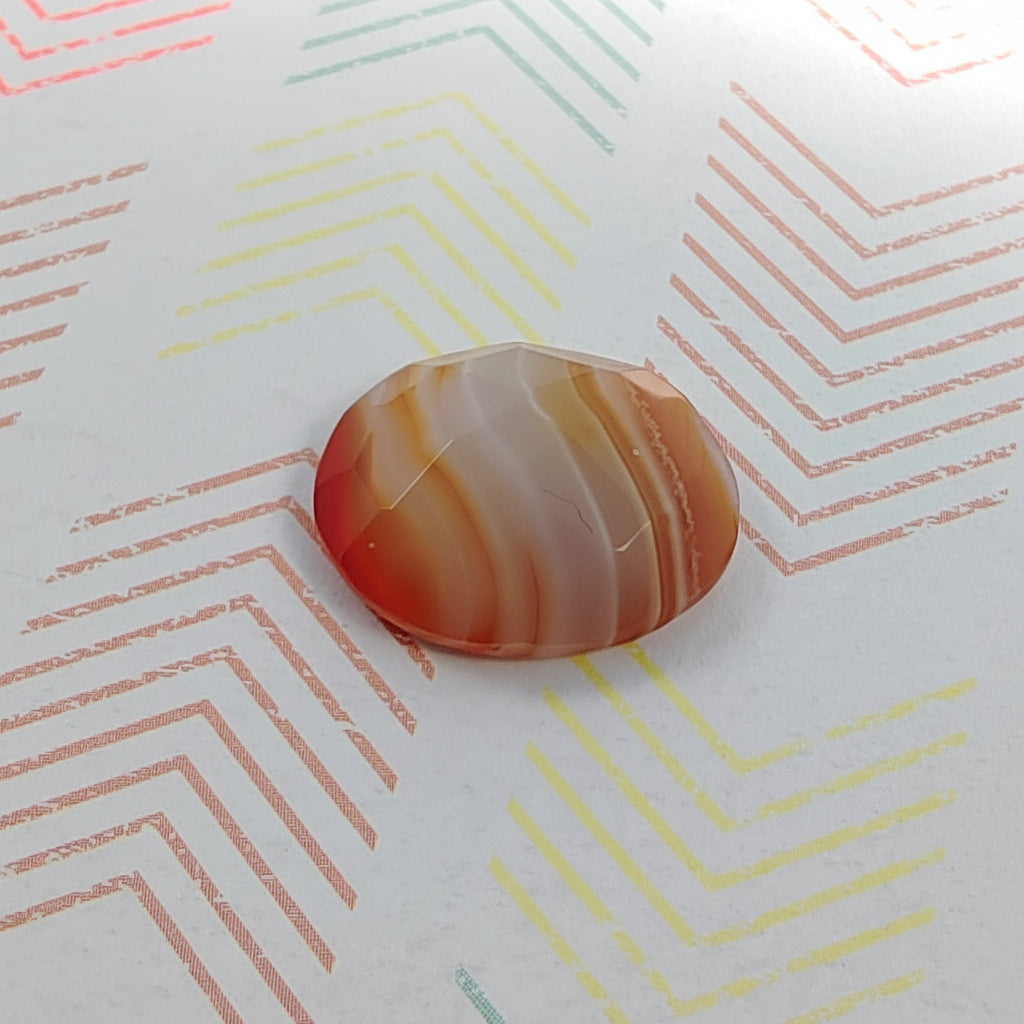 Polished agate stone on a paper with colorful geometric patterns