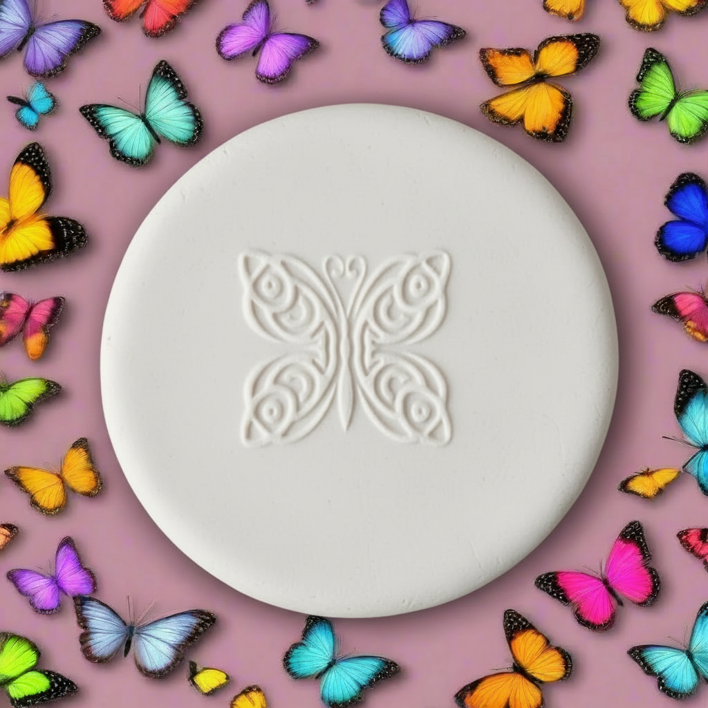A round white clay stamp with an embossed butterfly design in the centre, surrounded by a border of colourful artificial butterflies on a matching pink background.