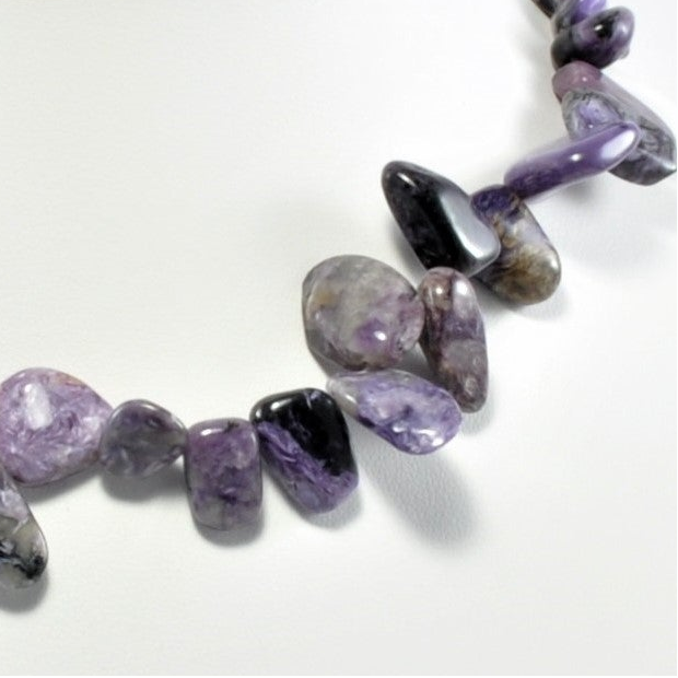 Necklace with purple and black beads on a white background