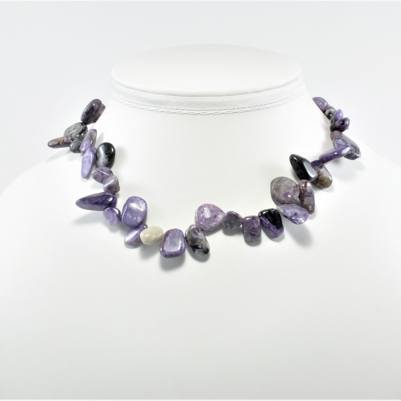 Necklace with purple and gray stones on a white background